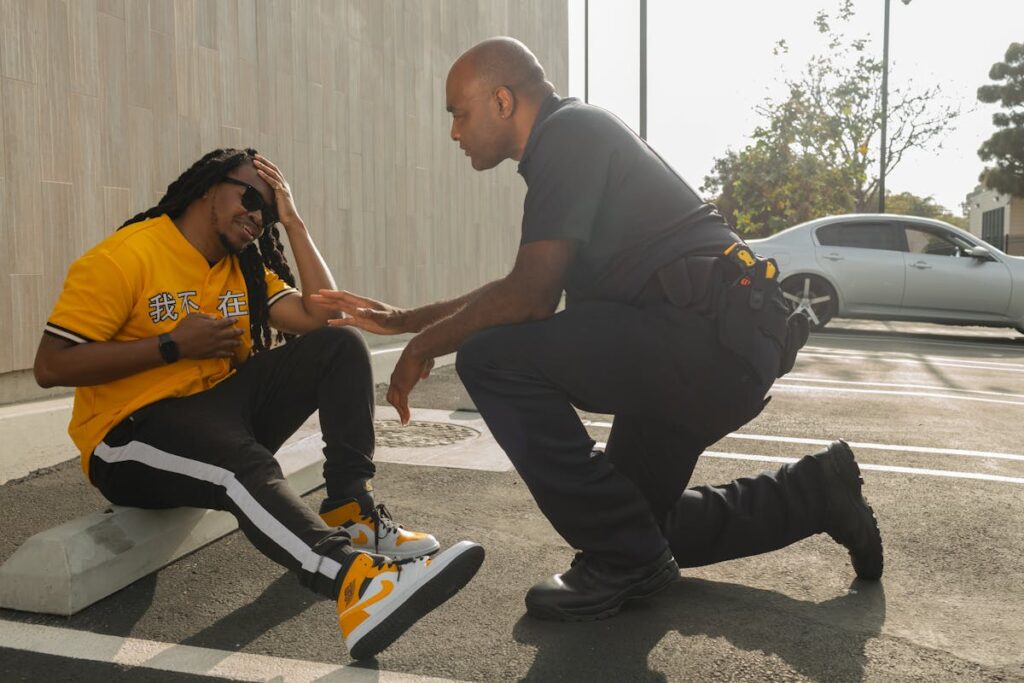 A police officer engages with a seated man outdoors