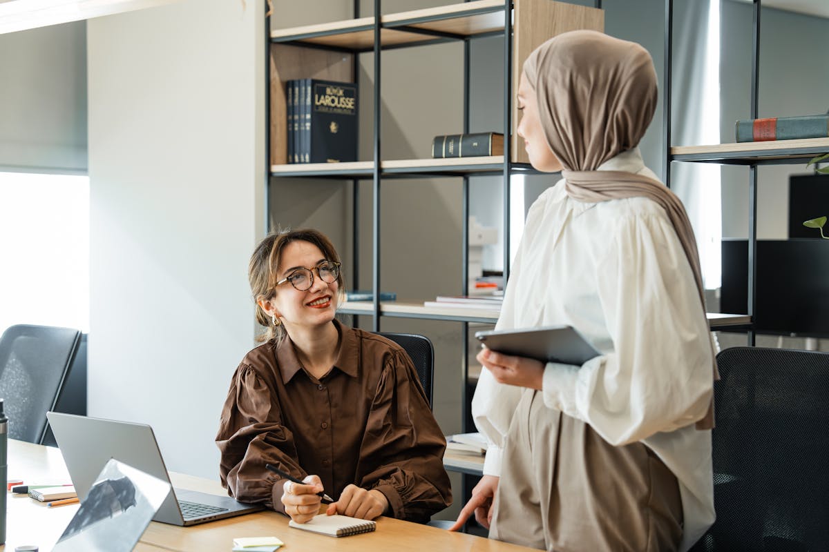 Two Women in an Office Interior with Shelve