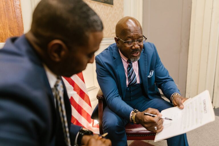 Men in Business Suit Looking at the White Paper with Printed