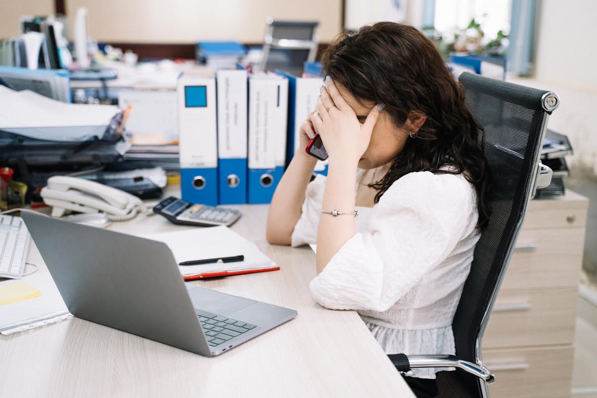 Woman Sitting Behind Her Desk Having a Telephone Call