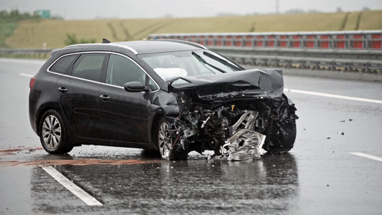 Badly Damaged Front of a Car on a Highway Right After Head On Ba