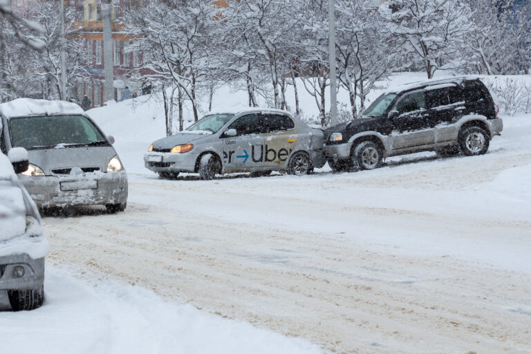 Magadan, Magadan Region, Russia - November 8, 2021. Car accident on the street. Two cars collided on a snow-covered slippery road. Damaged cars on the street. Lots of snow after a snowfall in the city