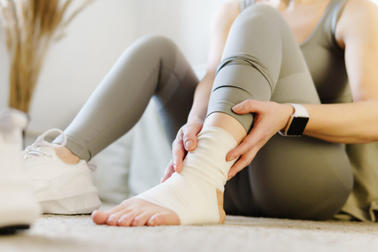 Sport injury leg pain - woman hurting holding painful sprained ankle muscle. Female athlete with joint or muscle soreness and problem feeling ache.