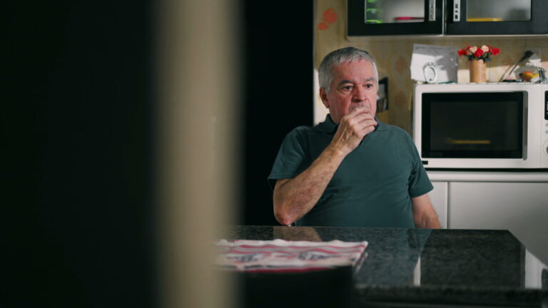 Drunk Senior Man Nodding Off at Kitchen Table, Struggling with Alcoholism at Home